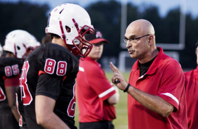 Coach Explaining American Football  Players On Field